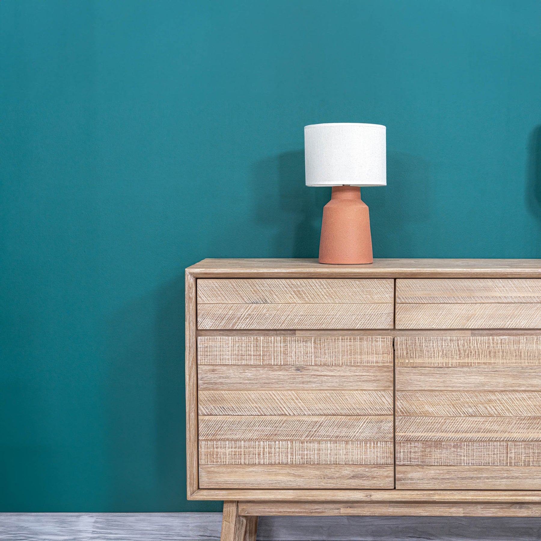 Front perspective view of the Gia sideboard featuring natural wood construction with horizontal textured paneling and three top drawers