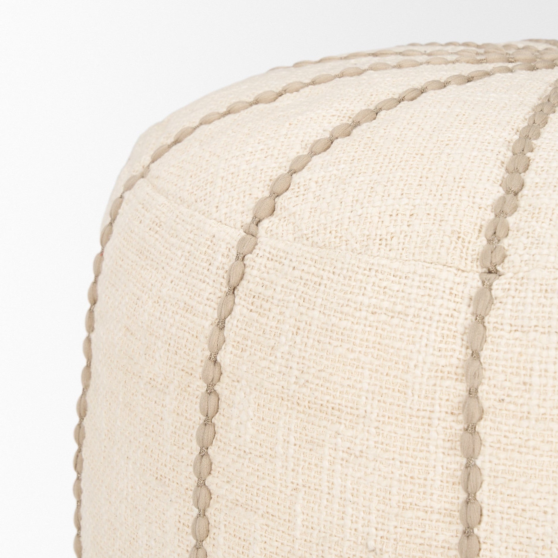 Front view of the Sachi round pouf in beige textured fabric with decorative vertical brown stitching creating a ribbed effect