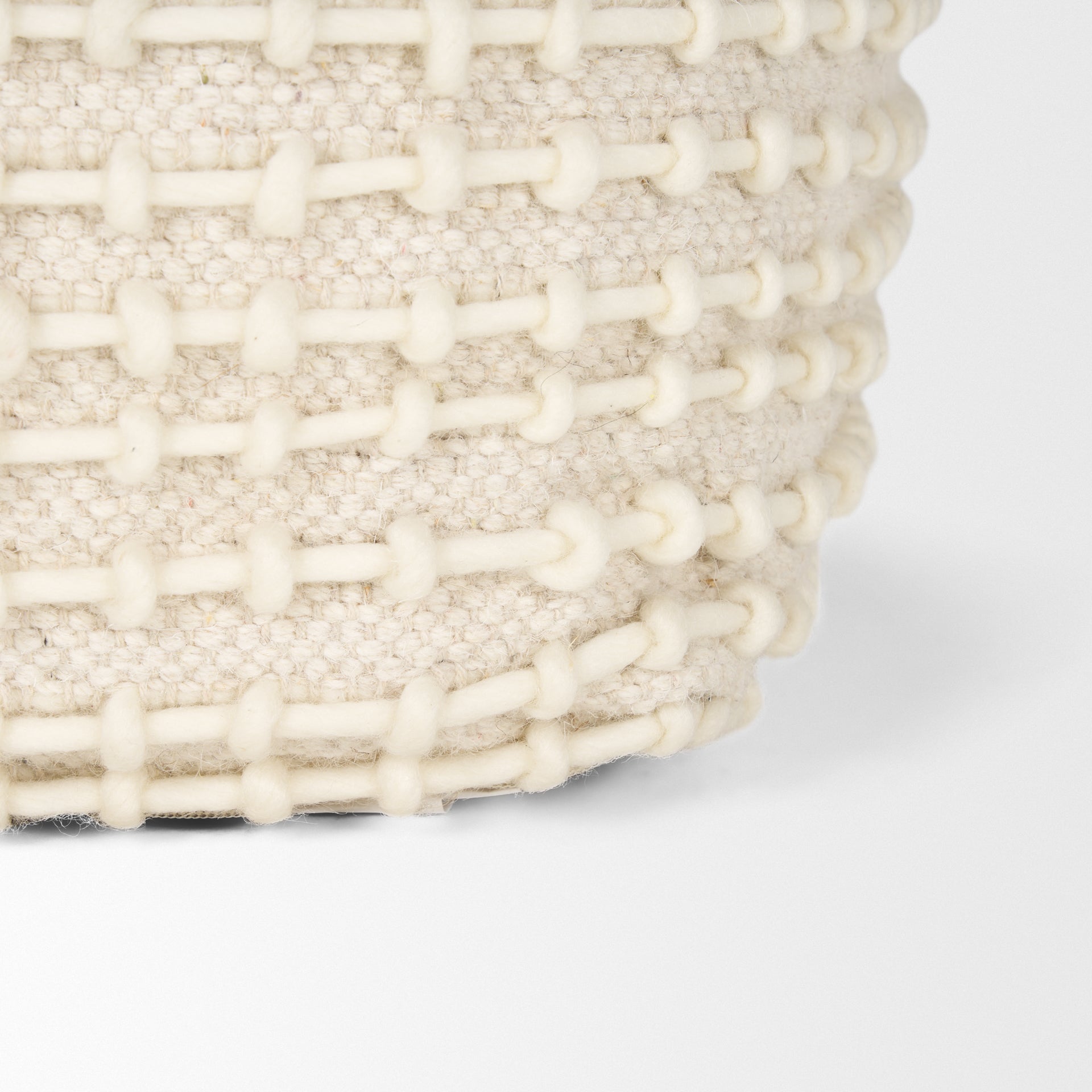 Straight-on front view showing the uniform square silhouette and consistent cream stitching across the beige surface