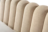 Close-up shot focusing on the high-quality cream bouclé fabric and the vertical channel tufting of the scalloped headboard