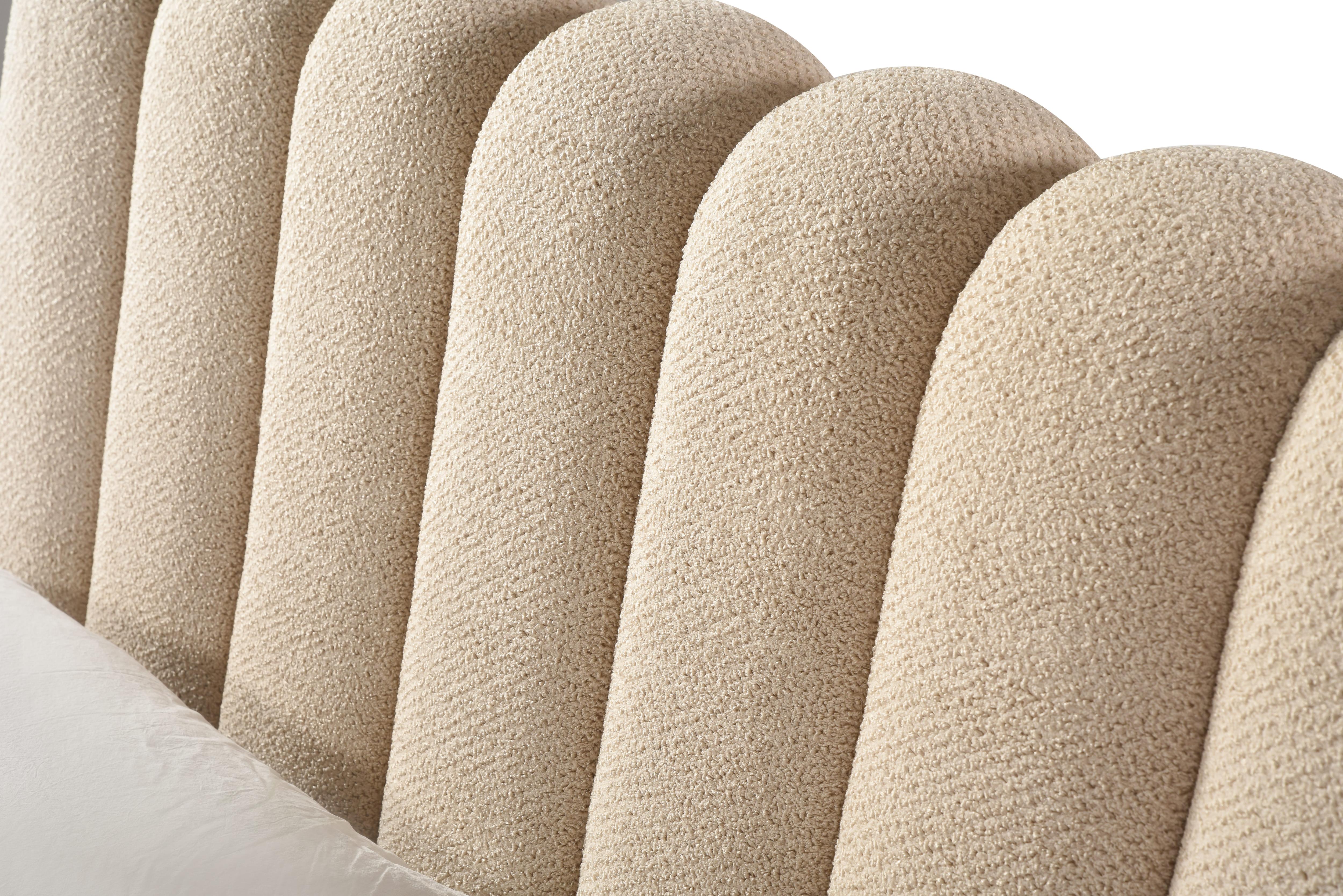 Front view of the Eira upholstered storage bed featuring a cream bouclé finish and a unique curved scalloped headboard
