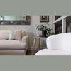 Interior styling view of the side table positioned between two white armchairs showcasing its slim profile