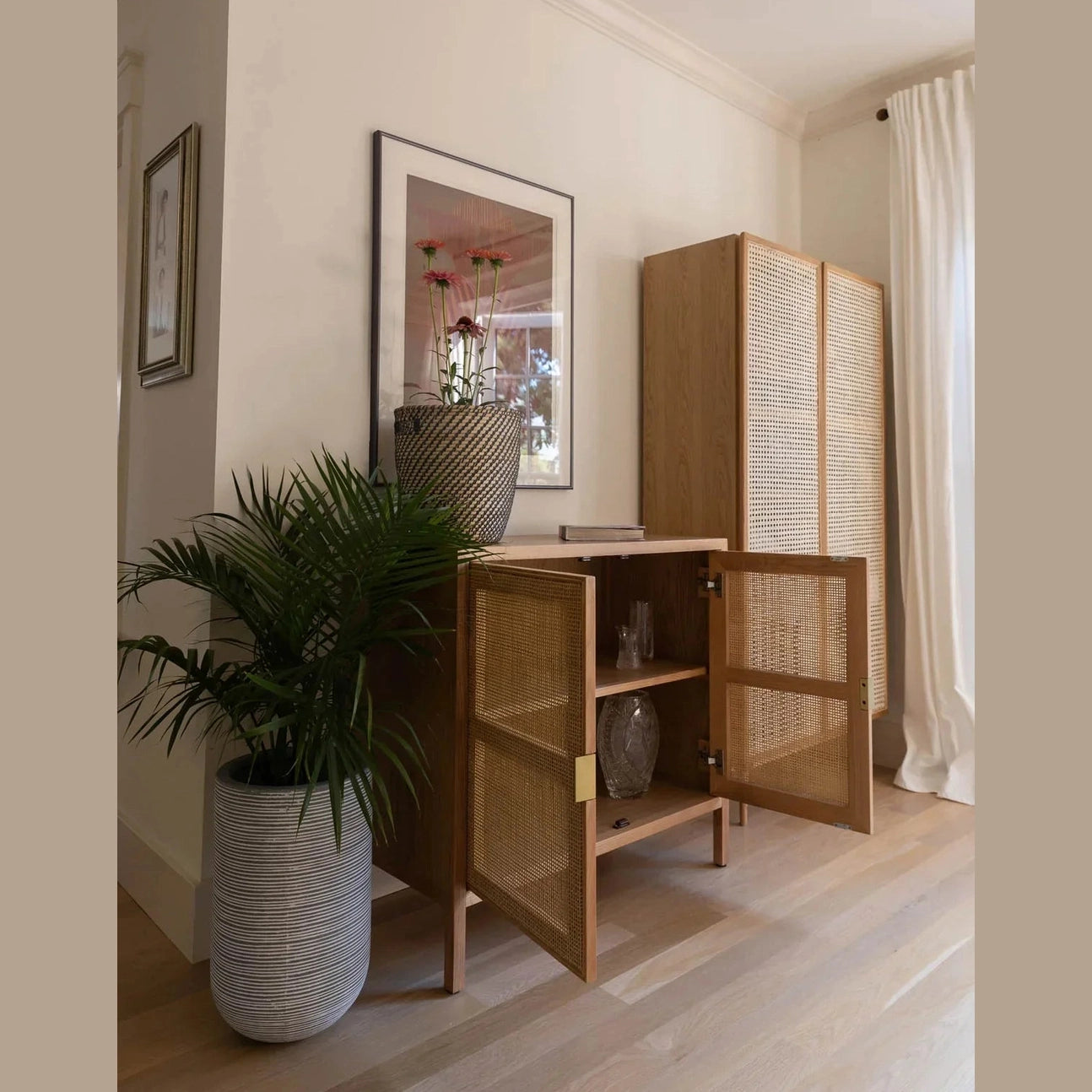 Straight-on front view highlighting the symmetrical woven rattan door inserts and clean wood frame