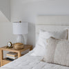 Final lifestyle perspective showcasing the bed styled with a wood bedside table and modern ceramic accents