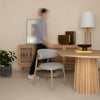 Lifestyle shot featuring the round oak table in a coordinated dining space with a matching wood sideboard