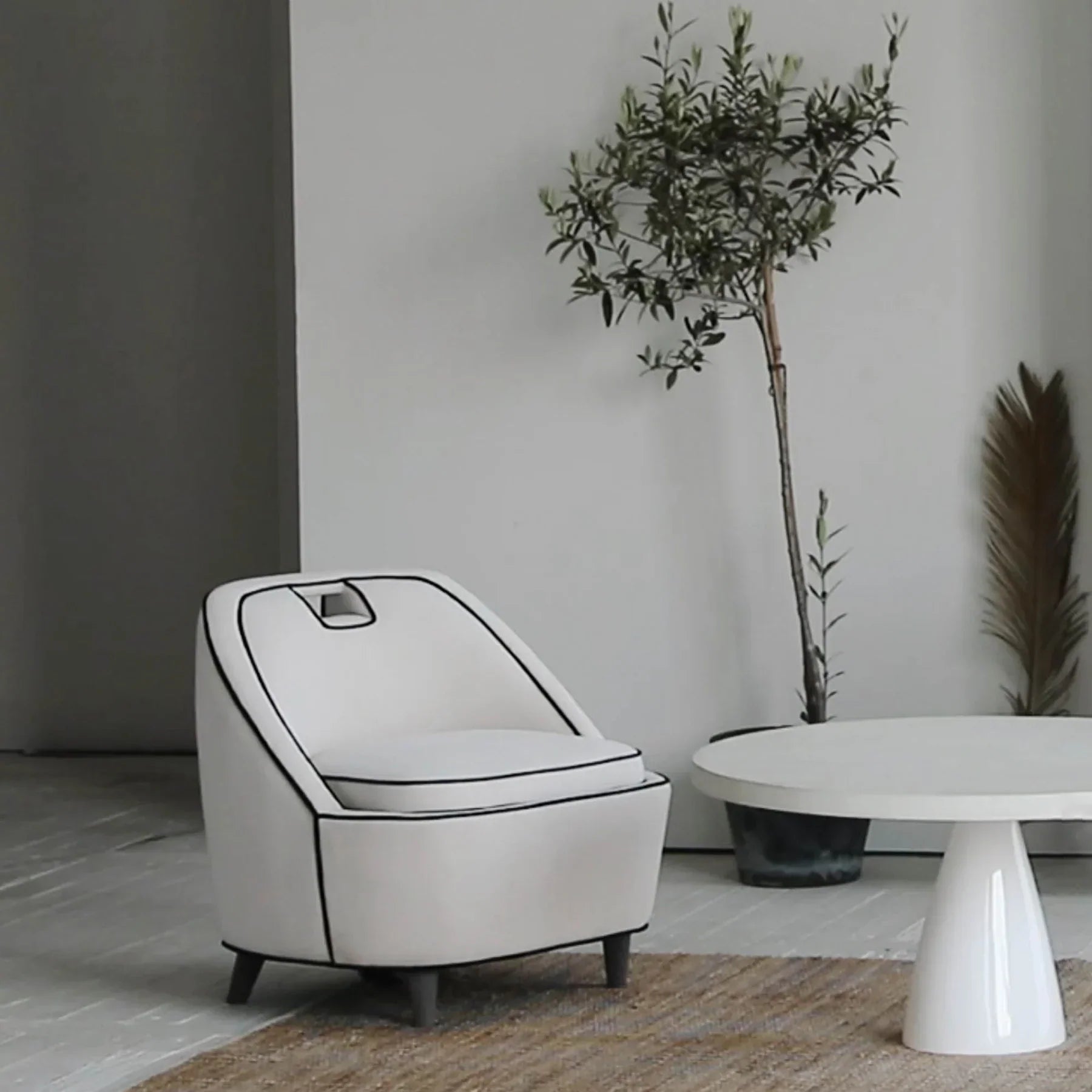 Front view of the Sculpture coffee table featuring a large circular top and a tapered conical pedestal base in a smooth white concrete finish