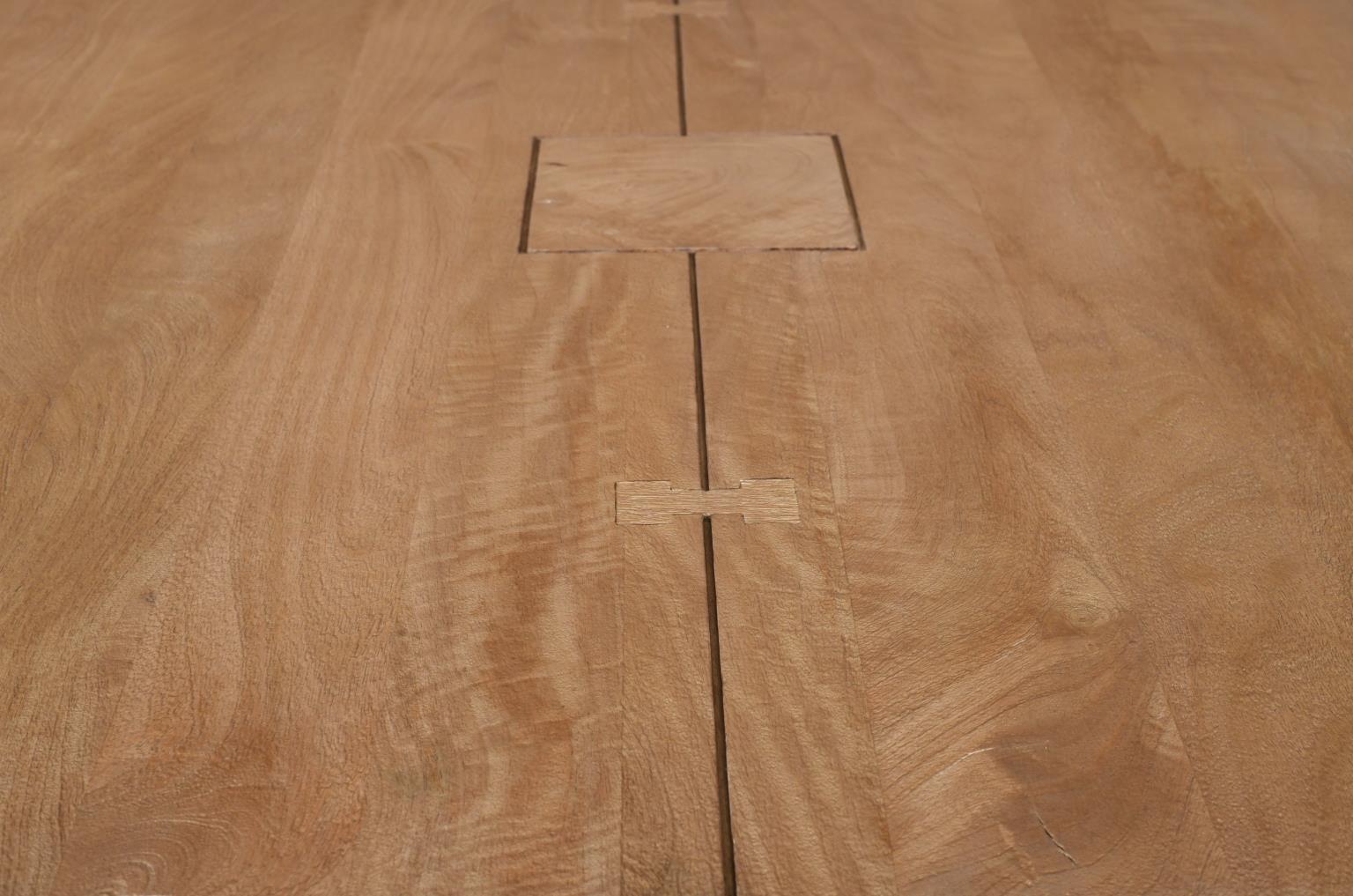 Detailed view of the tabletop highlighting the natural wood texture and artisanal butterfly joint craftsmanship