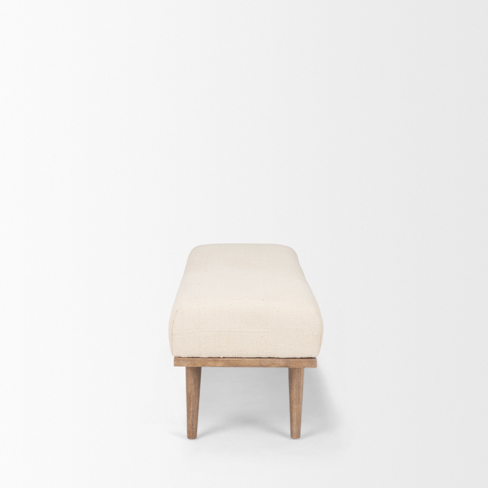 Front view of the Shae bench featuring a plush oatmeal-colored upholstered seat and a tapered brown wood frame