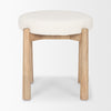 Lifestyle shot featuring the Shaiden stool styled in a modern entryway next to a large vase and abstract wall art