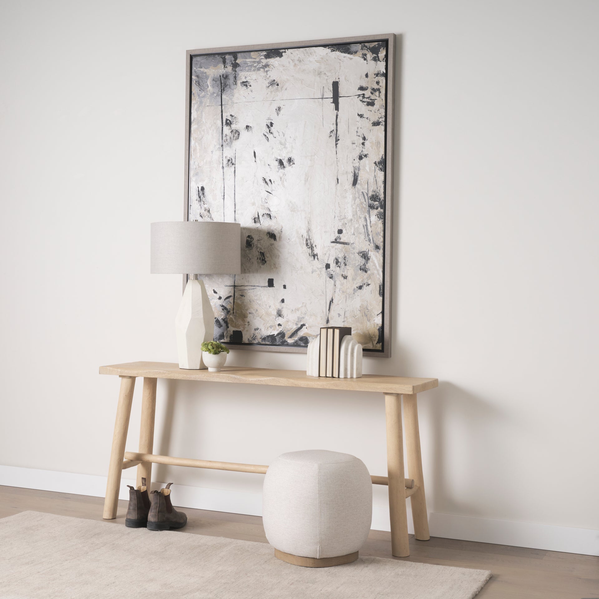 Front three-quarter view of the Siren round accent stool featuring cream textured fabric and a light brown wood base