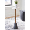 Lifestyle shot featuring the white marble version of the Caramont table styled with a marble vase in a bright interior