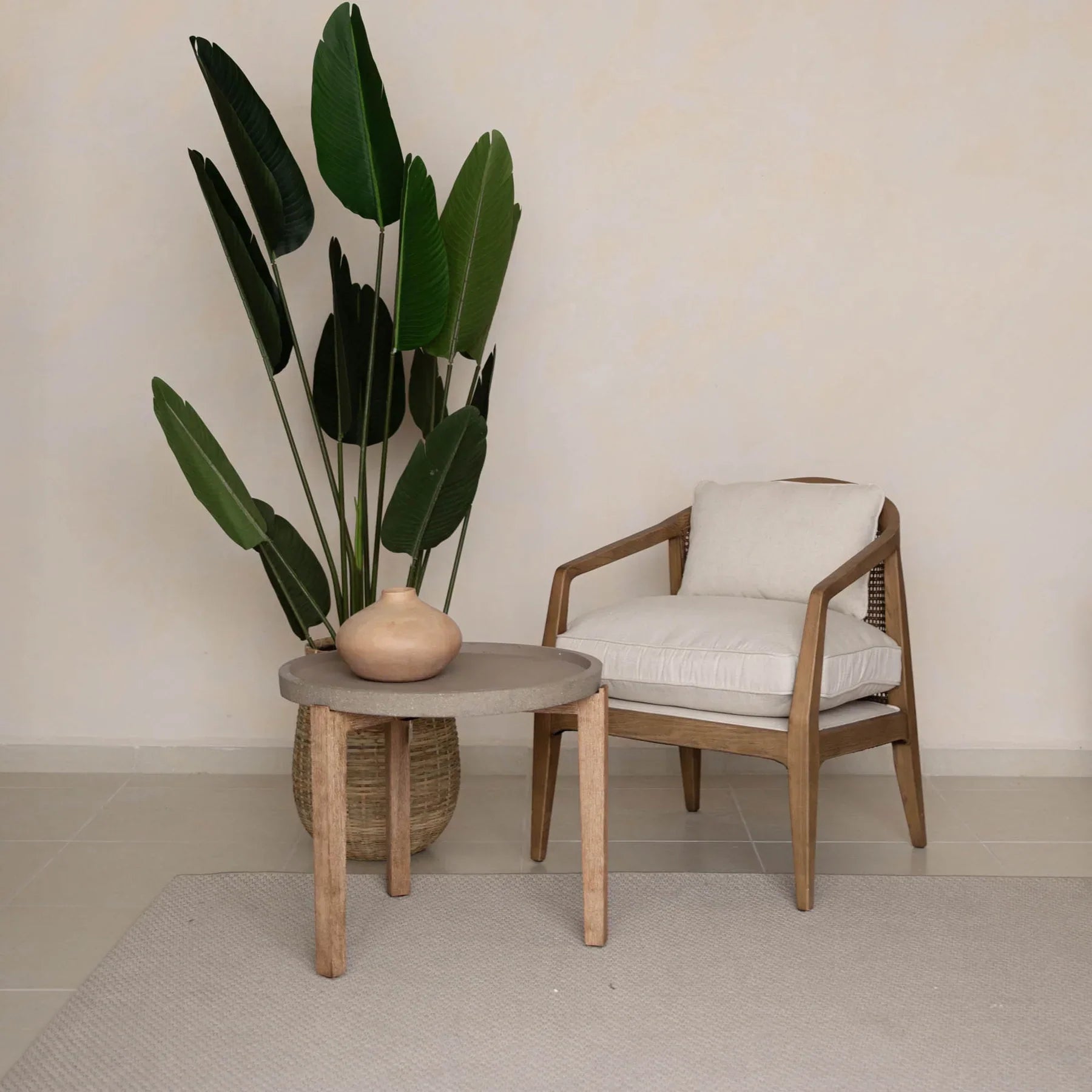 Front view of a small round patio garden table featuring a textured brown stone top and three tapered natural wood legs