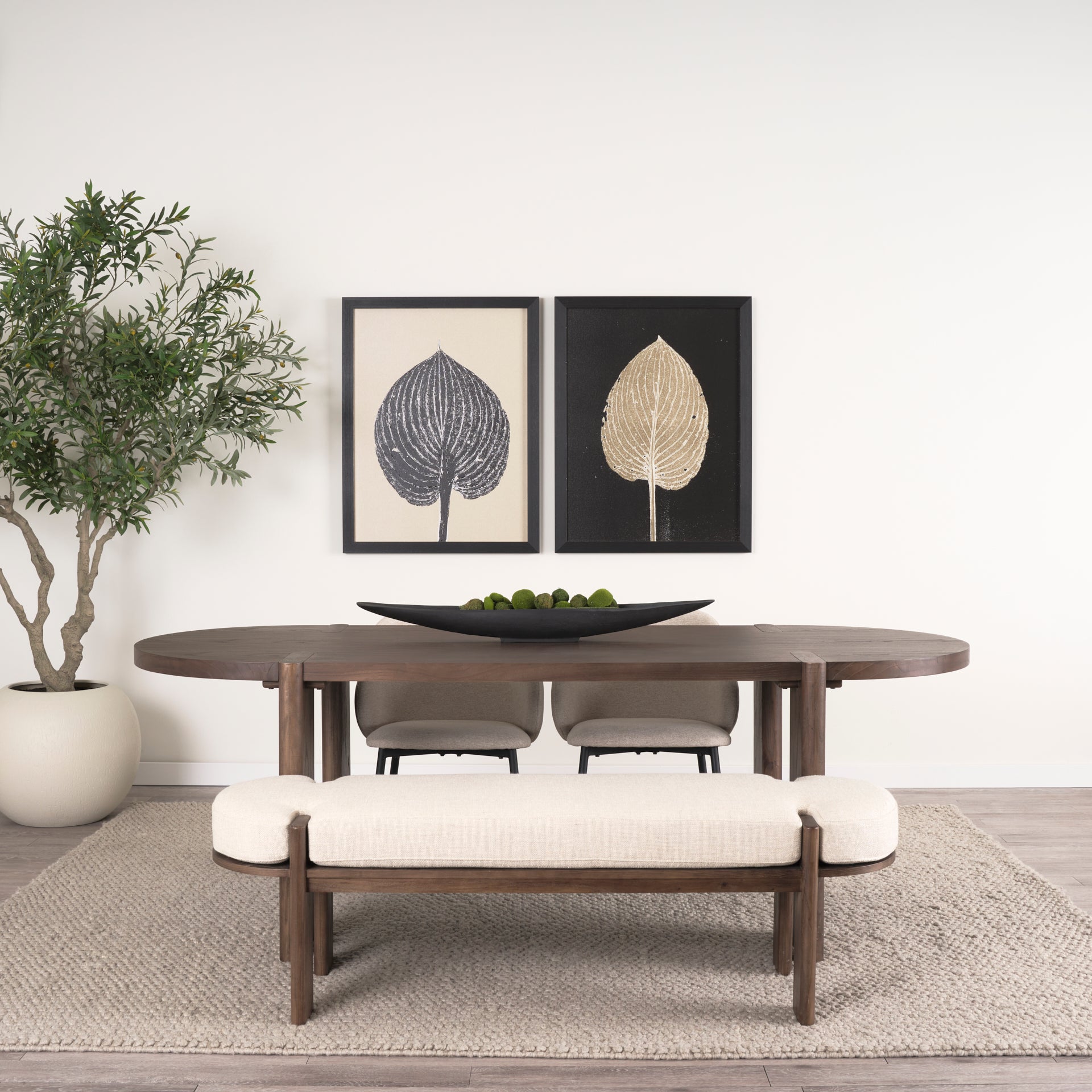 Front view of the Sohan oval dining table in a dark elm wood finish featuring smooth rounded edges and sturdy trestle leg supports