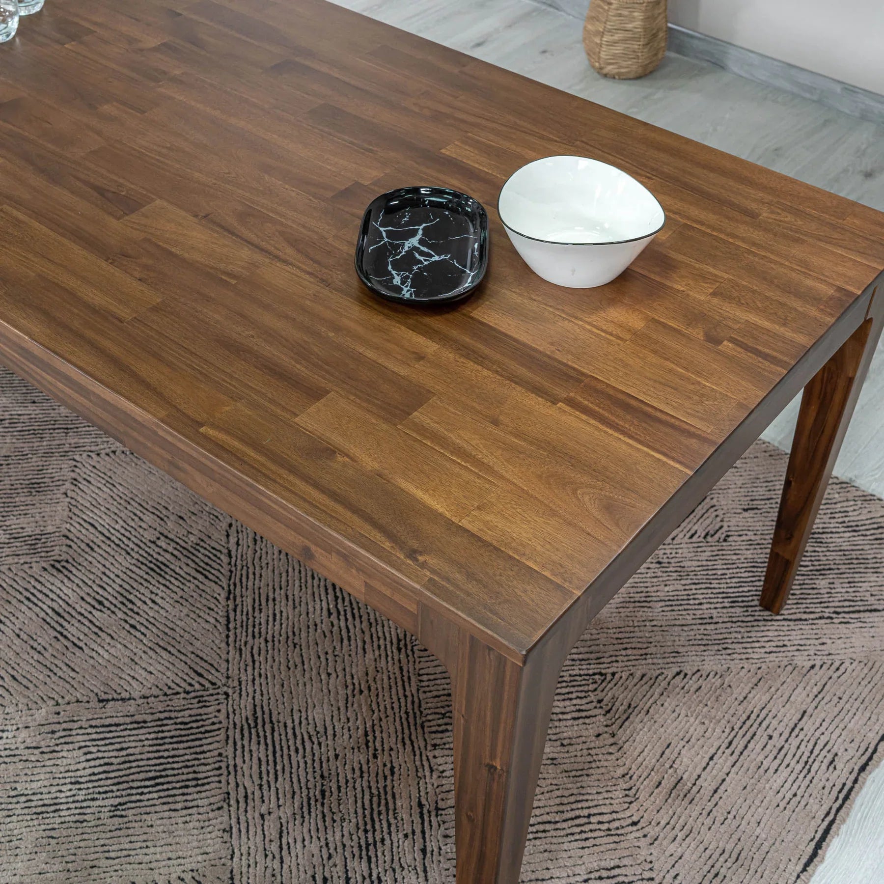 Front view of the Allure dining table in a rich walnut-toned acacia wood featuring a minimalist rectangular top and flared tapered legs