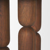 Detailed view of the sculptural table leg showing the unique narrow neck transition between the rounded tiered wood segments