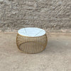 Lifestyle shot of the Soto coffee table styled in an outdoor setting against a rustic stone wall