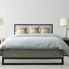 High-end lifestyle shot of the bed styled with crisp white linens and neutral pillows for a soft modern look