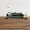 Lifestyle perspective demonstrating the table's scale as a functional accent piece beside a modern green leather couch