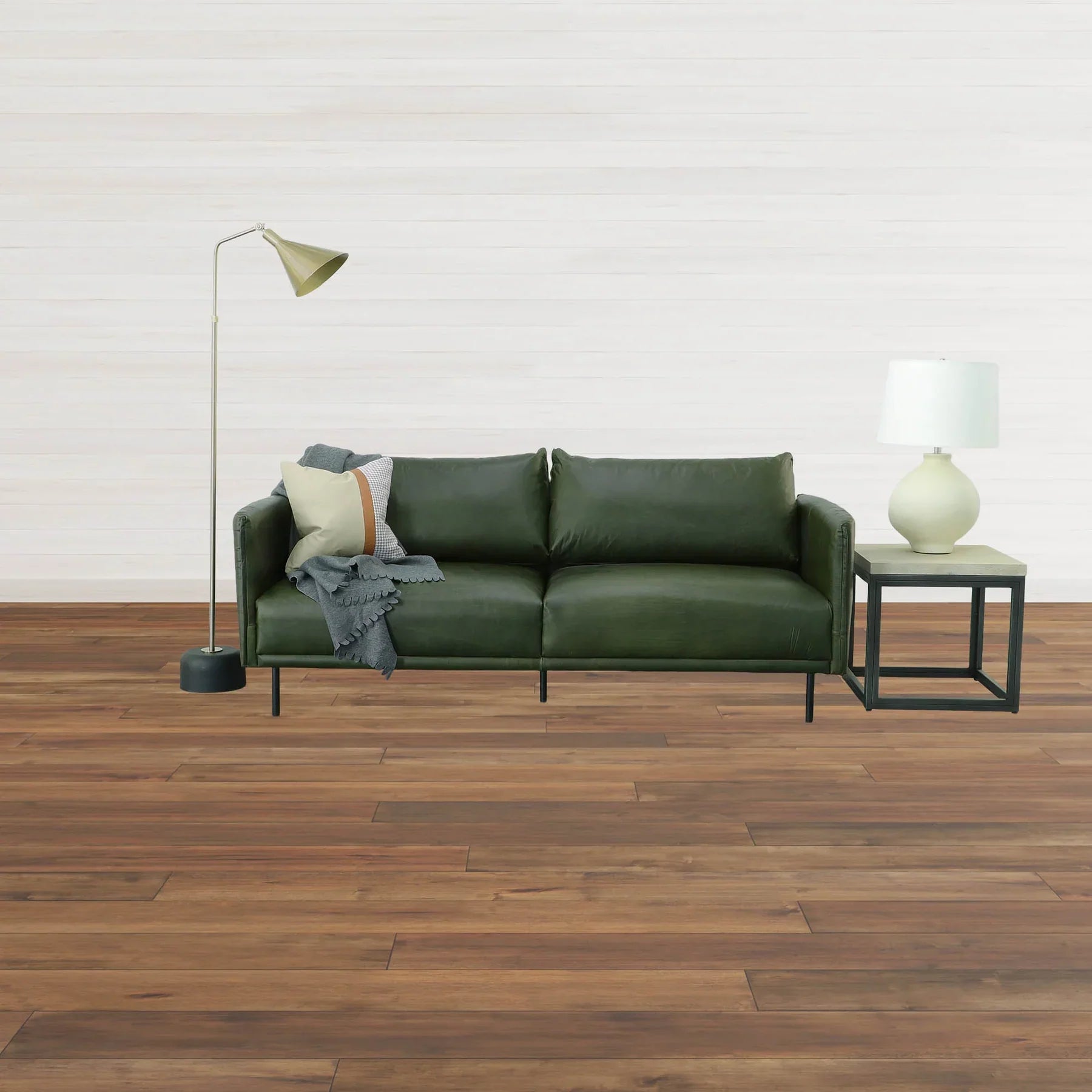Lifestyle perspective demonstrating the table's scale as a functional accent piece beside a modern green leather couch