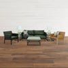 Lifestyle shot featuring the Starlight table styled next to a dark green leather sofa with mid-century modern armchairs