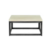 Front view of the Starlight coffee table featuring a square beige travertine top and a dark tapered pedestal base