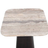Close-up high-angle shot focusing on the unique horizontal mineral veining and natural porous texture of the square travertine tabletop