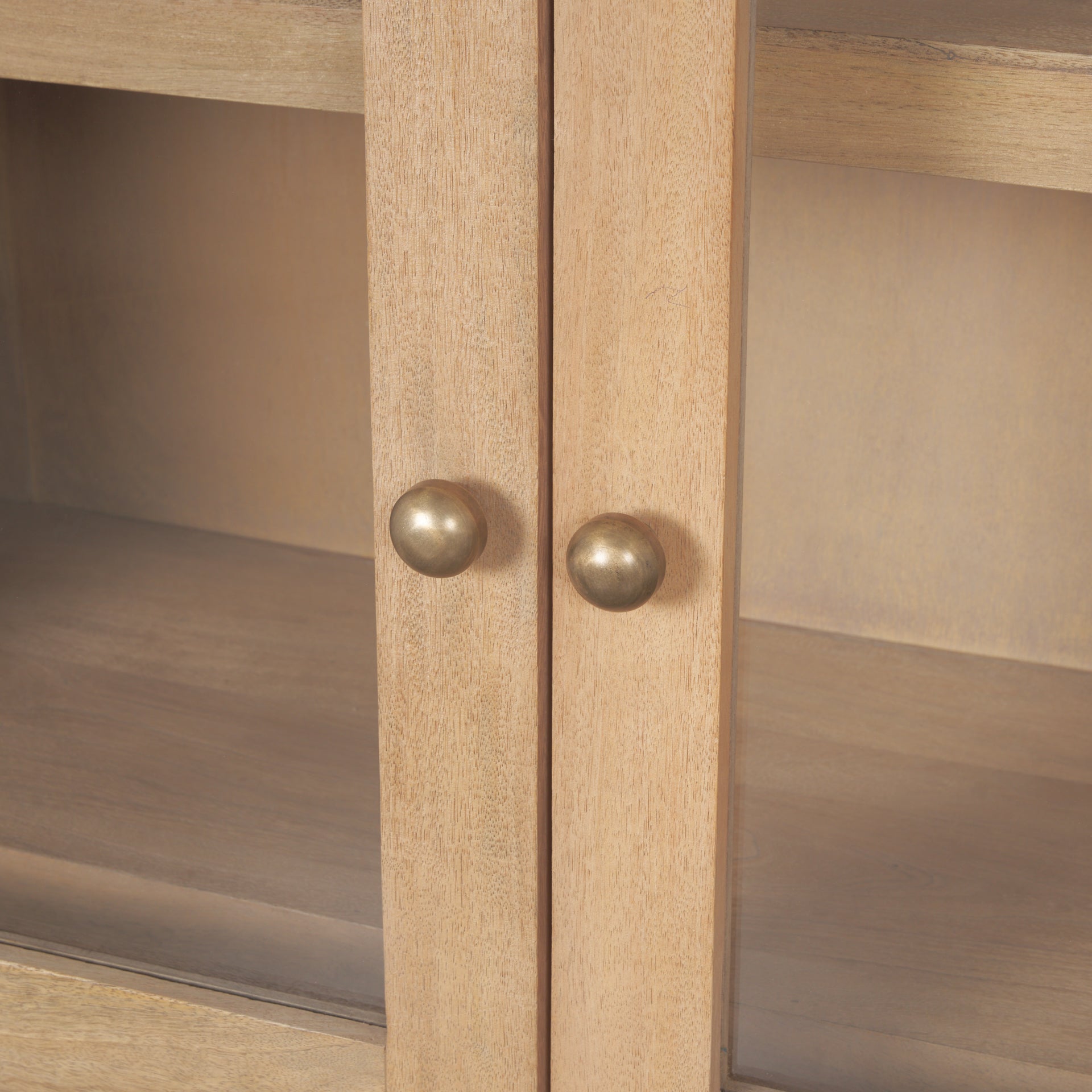 Close up of the round brass knob hardware on the Suri curio cabinet doors