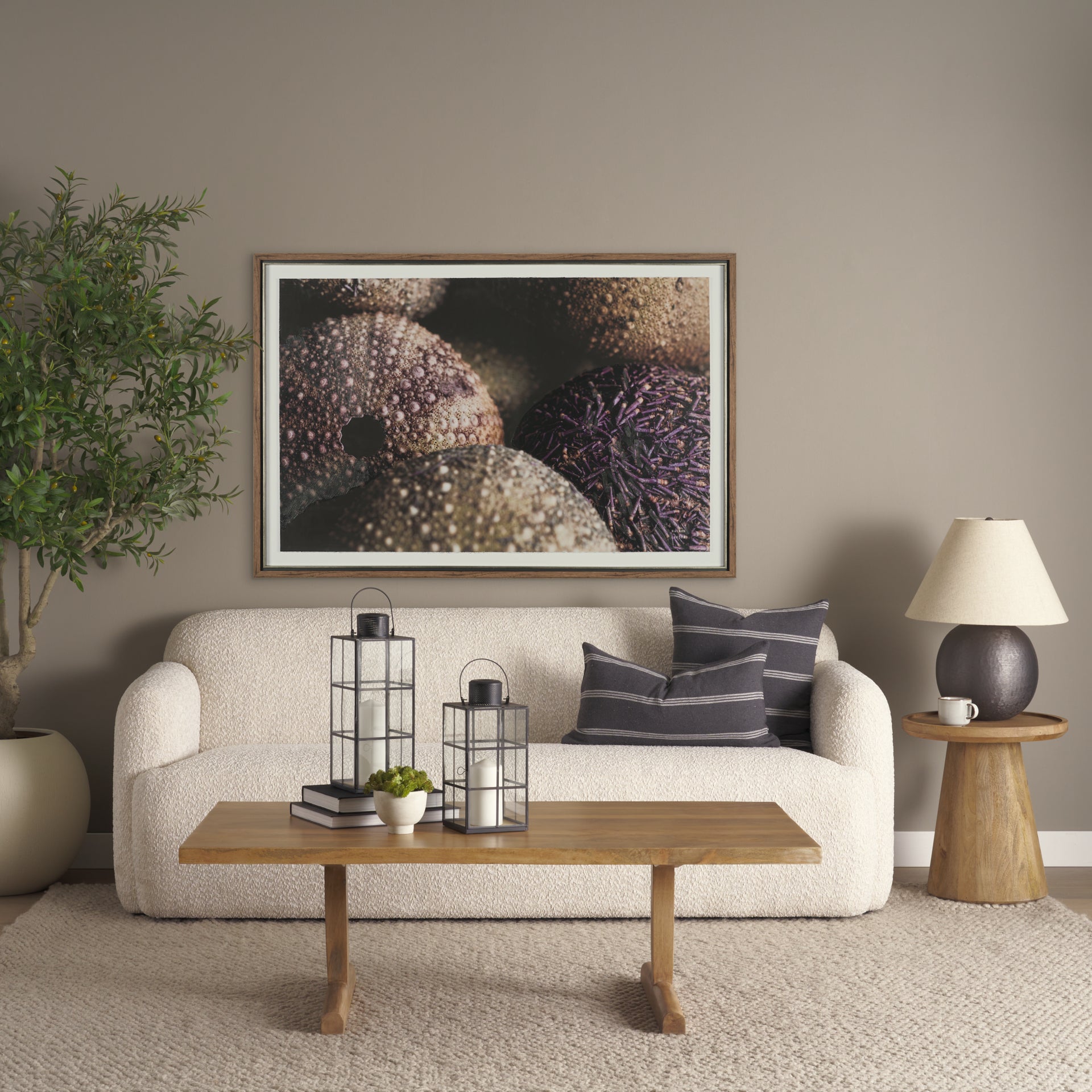 Front view of the Takoda accent table in light brown wood featuring a tapered drum pedestal base and a circular tray-style top