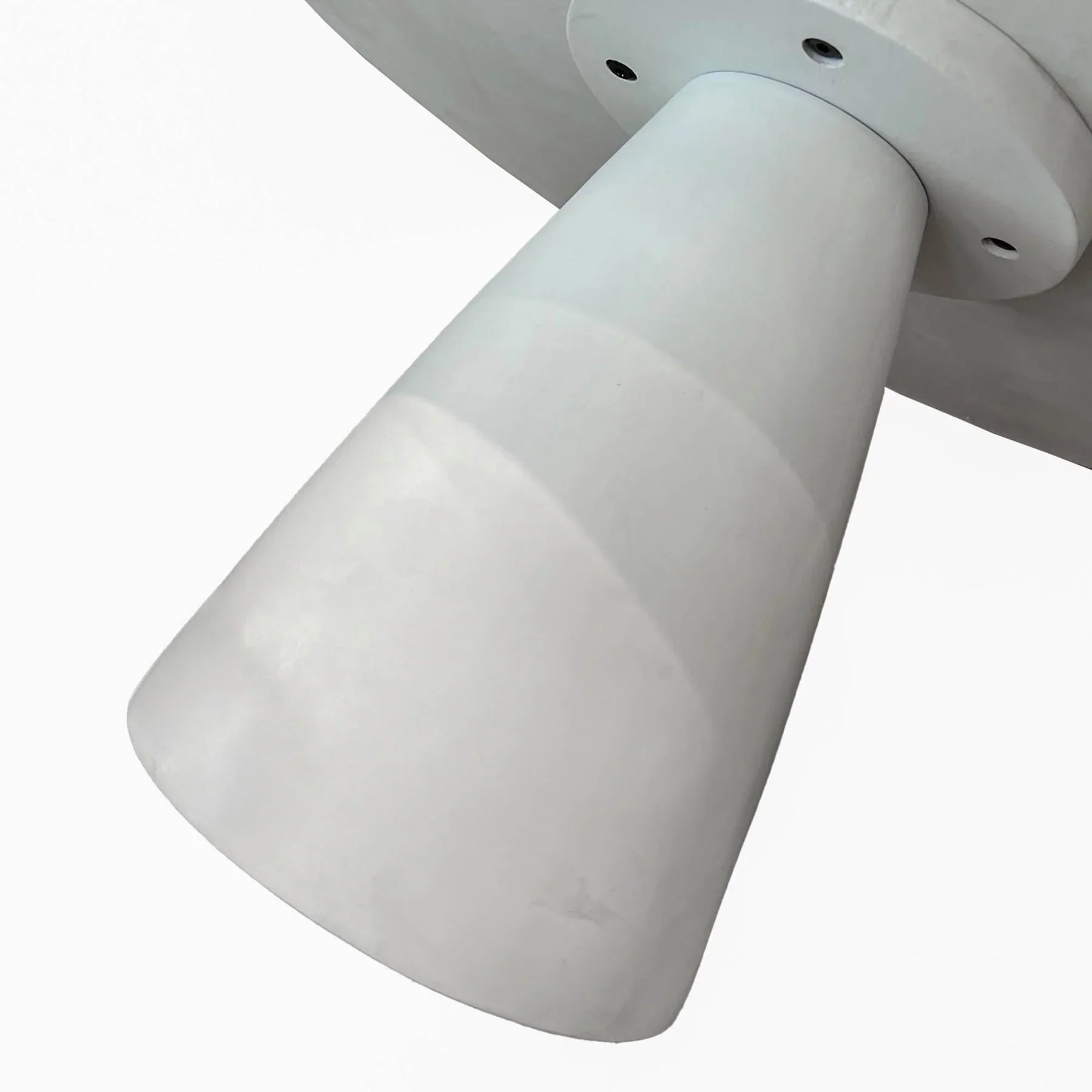 Front view of the Sculpture coffee table featuring a large circular top and a tapered conical pedestal base in a smooth white concrete finish