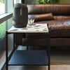Lifestyle view of the table styled with a sculptural bust and decor in a contemporary living space