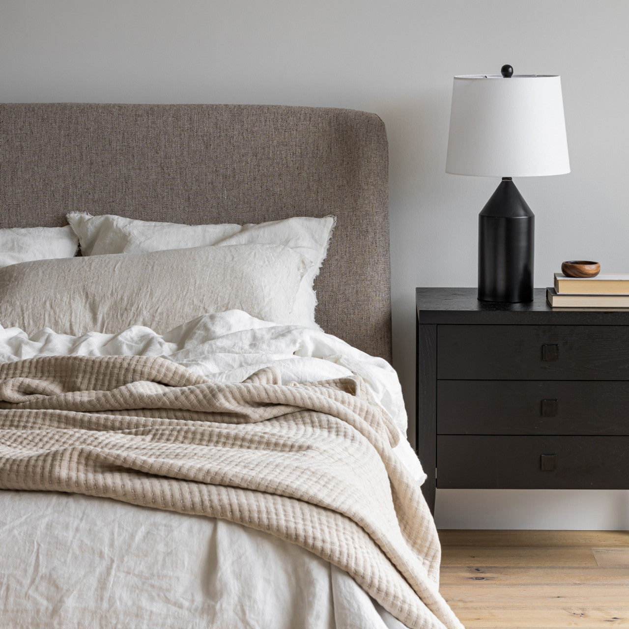 Front view of the Faye platform bed featuring a curved wingback headboard and textured taupe fabric upholstery