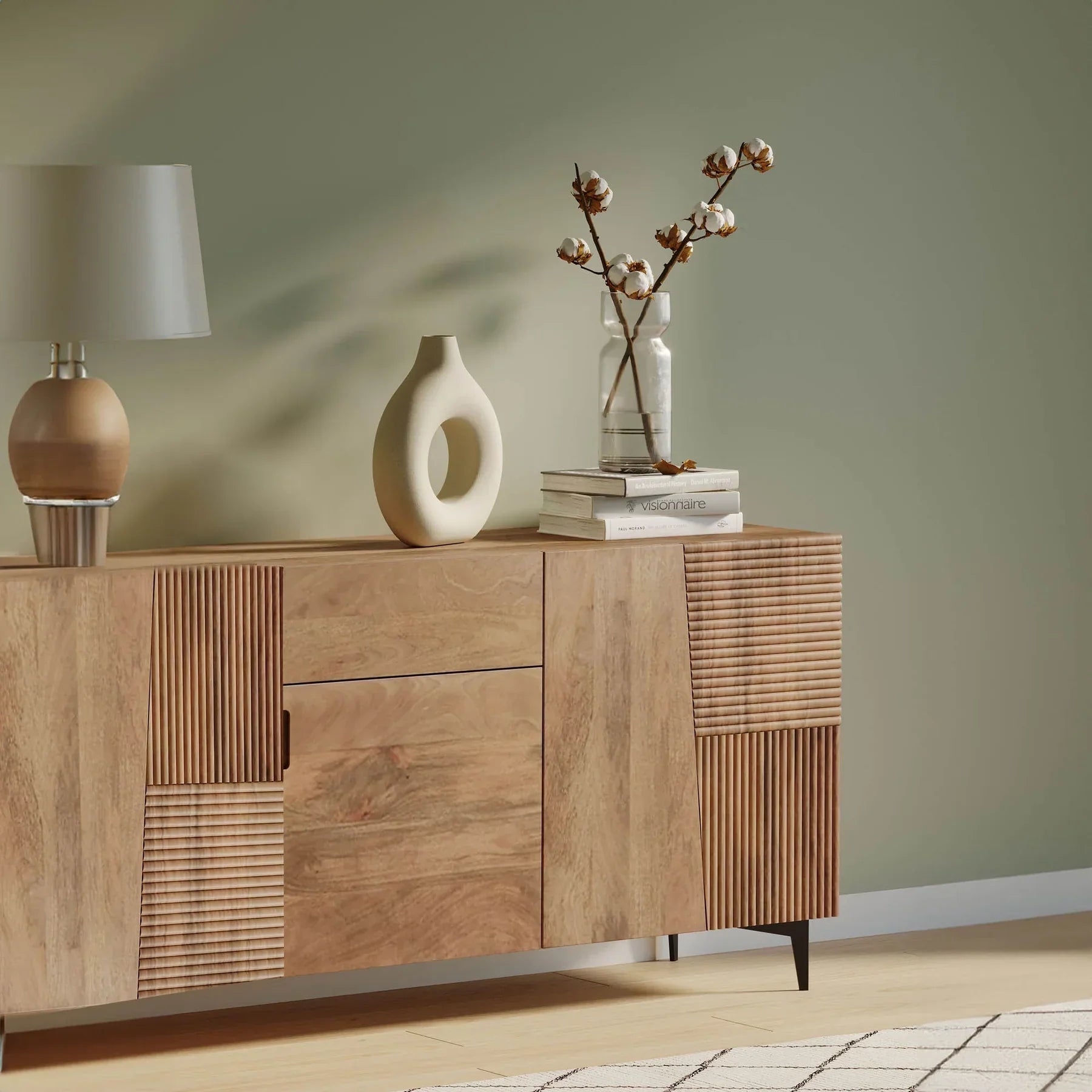 Front view of the Peyton sideboard featuring natural mango wood construction with unique geometric carved door panels and black metal legs
