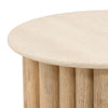 Three-quarter perspective highlighting the low profile and thick stone surface of the Thandi round coffee table
