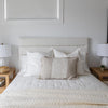 Straight-on view of the tufted headboard styled with symmetrical white pillows for a clean, balanced look