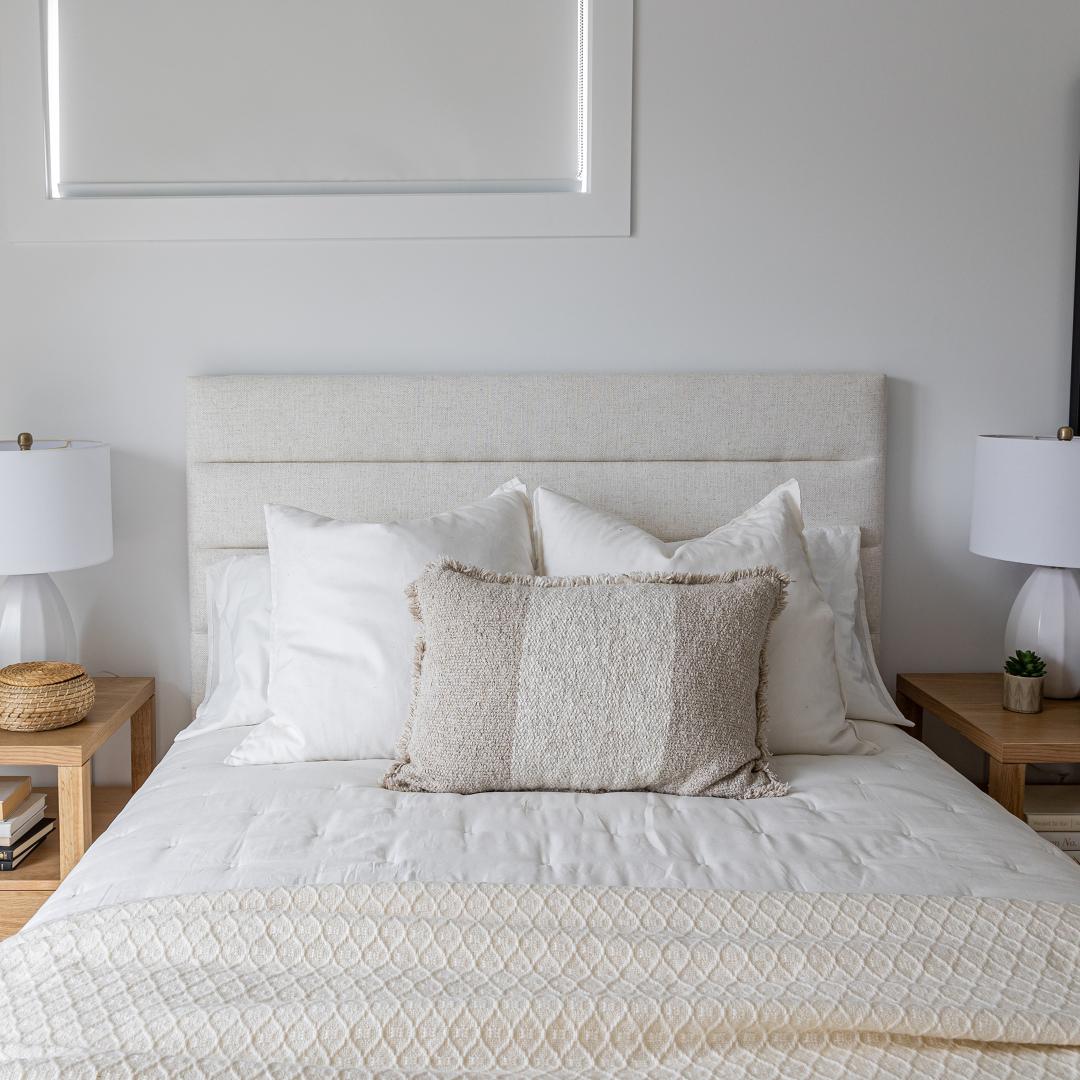 Straight-on view of the tufted headboard styled with symmetrical white pillows for a clean, balanced look