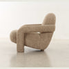 Side profile demonstrating the organic curved backrest and the substantial thickness of the upholstered frame