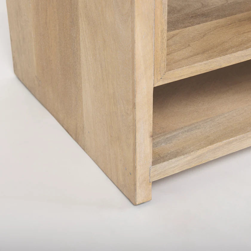 Three-quarter perspective view of the Traro shelving unit in blonde wood featuring a unique geometric honeycomb compartment design