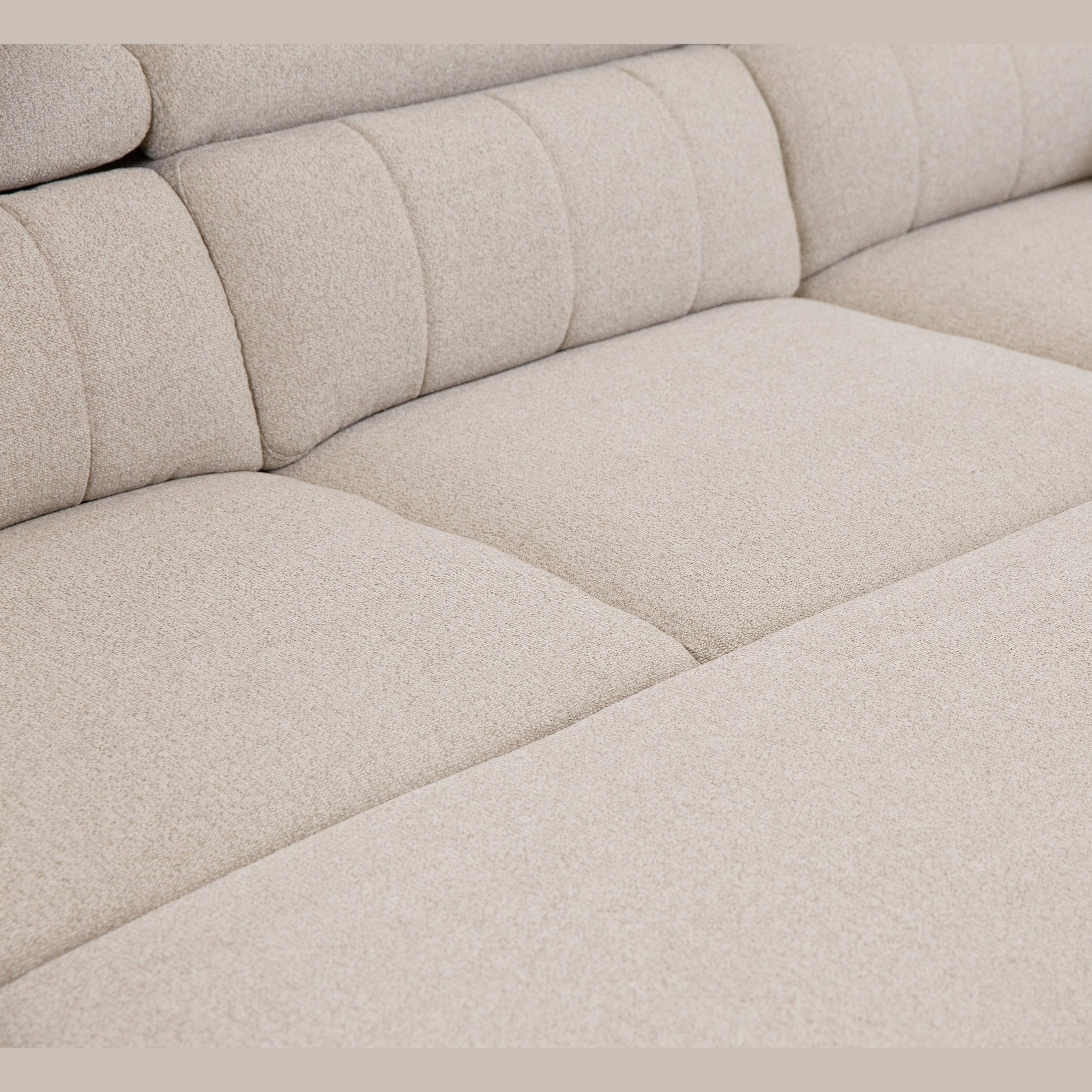 Front view of the Tristan Sleeper Sectional in Fritillary cream fabric with adjustable headrests and storage ottoman