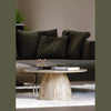 Lifestyle view of the Truffle coffee table positioned in front of a dark contemporary sofa in a modern interior