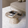 High-angle lifestyle shot featuring the Truffle table on a white plush rug styled with books and decorative objects
