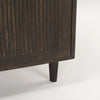 Detail shot of the tapered leg and base joinery on the dark wood cabinet