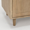 Detail shot of the tapered leg and base joinery on the light wood cabinet