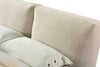 Detailed view of the rounded bed frame corner highlighting the plush cushioning and neutral cream upholstery