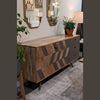 Lifestyle shot in a loft-style room showcasing the sideboard styled with arched mirrors and industrial lighting