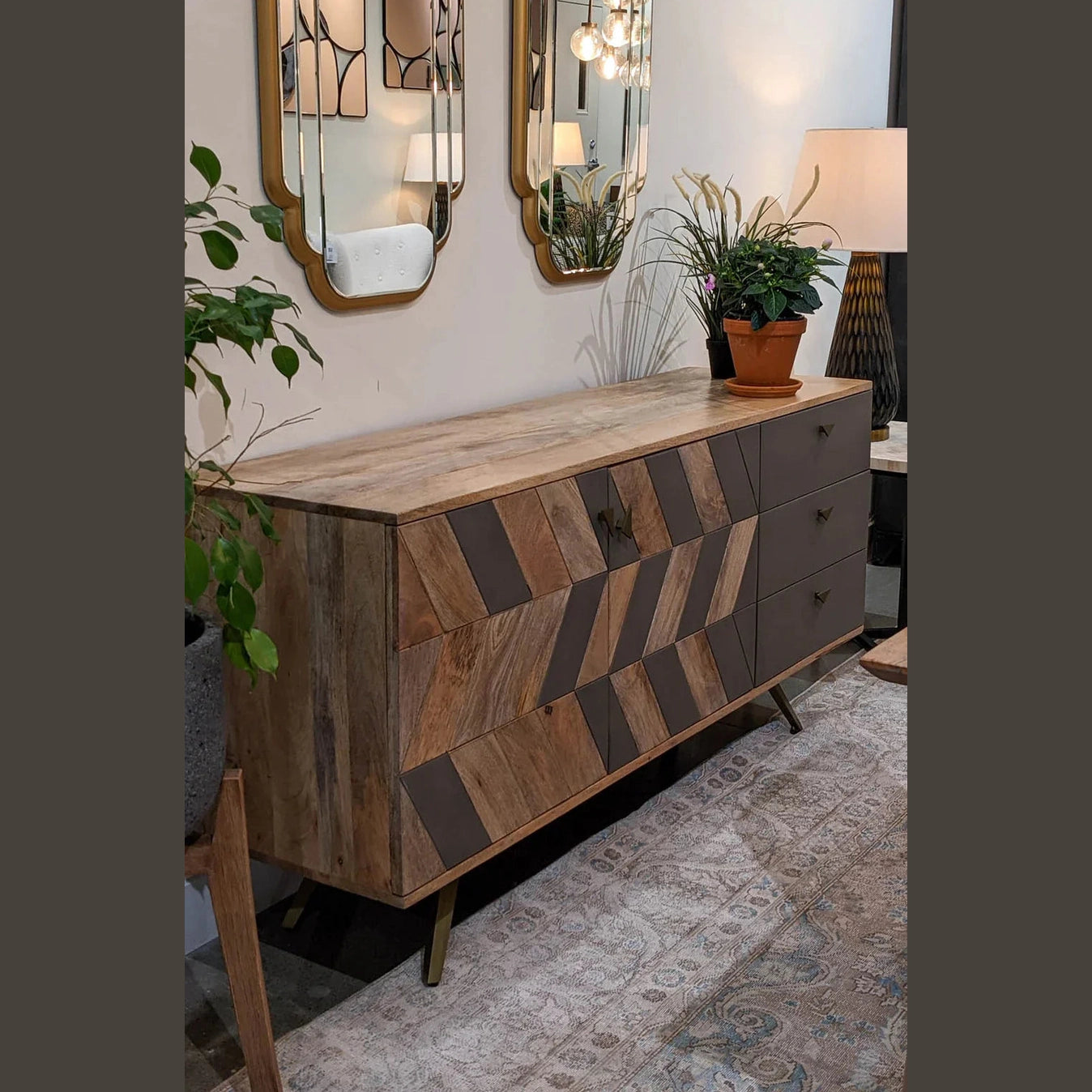 Three-quarter perspective view of the London sideboard featuring a chevron wood pattern combined with solid grey panels and gold tapered legs