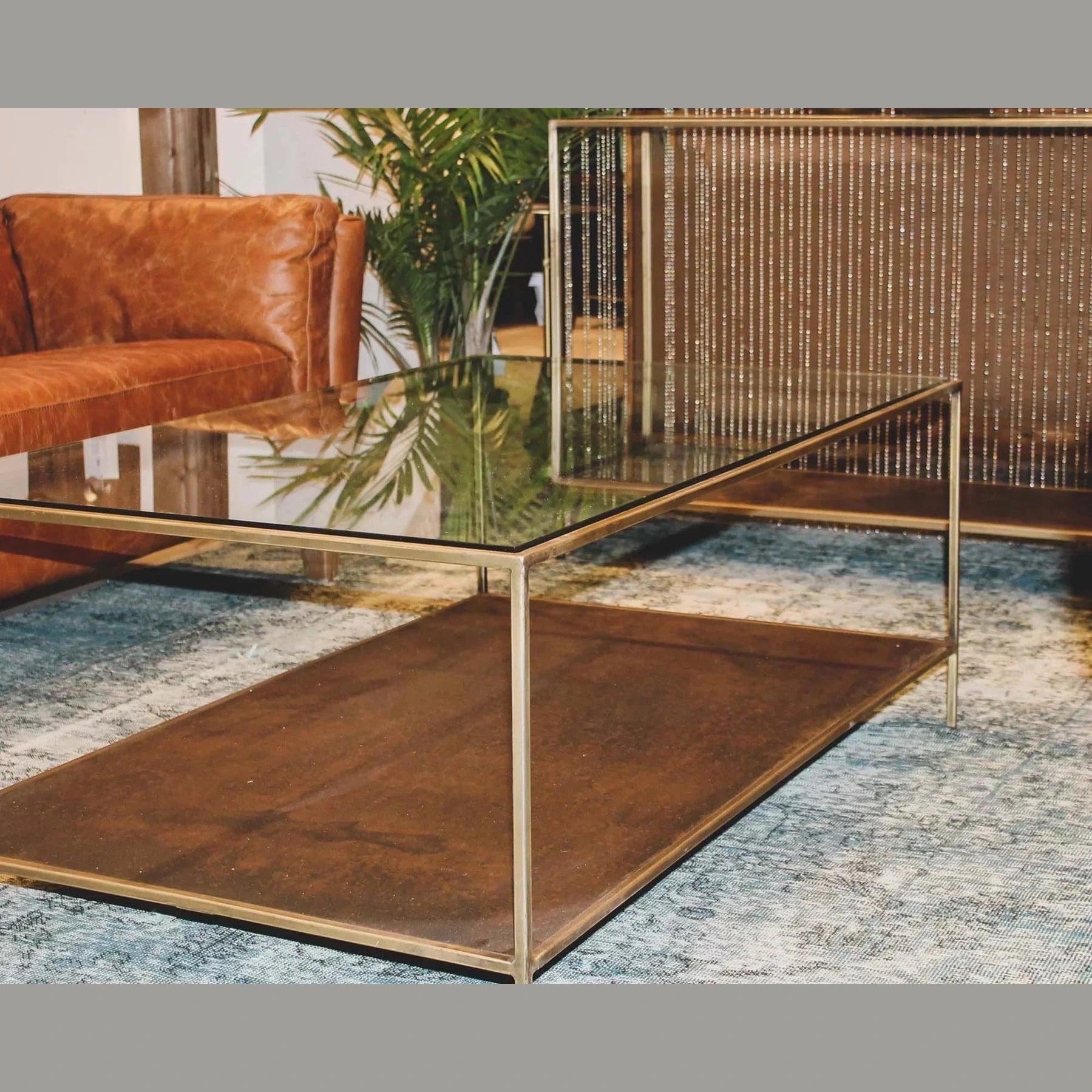 Front view of the Venus coffee table featuring a circular beige travertine top supported by a thick cylindrical base with vertical wood fluting