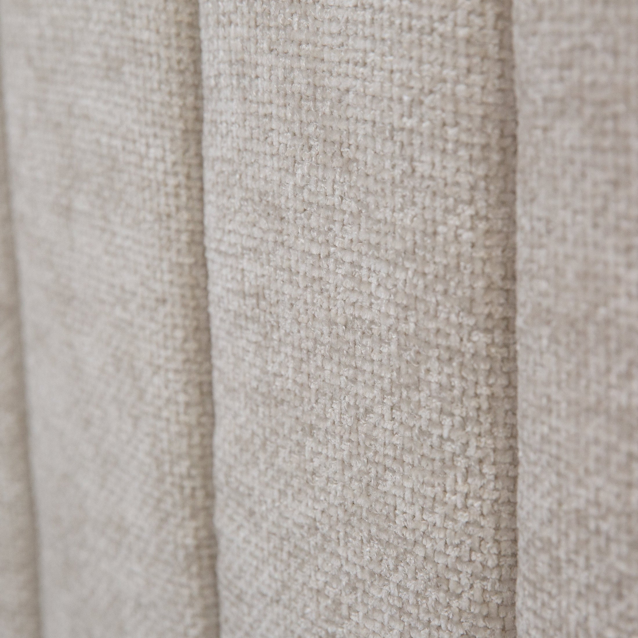 Front view of the Norell storage bed featuring a neutral woven fabric finish and a vertical channel tufted headboard