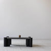 Lifestyle view showing the Vito coffee table styled in a bright minimalist studio with a white brick floor