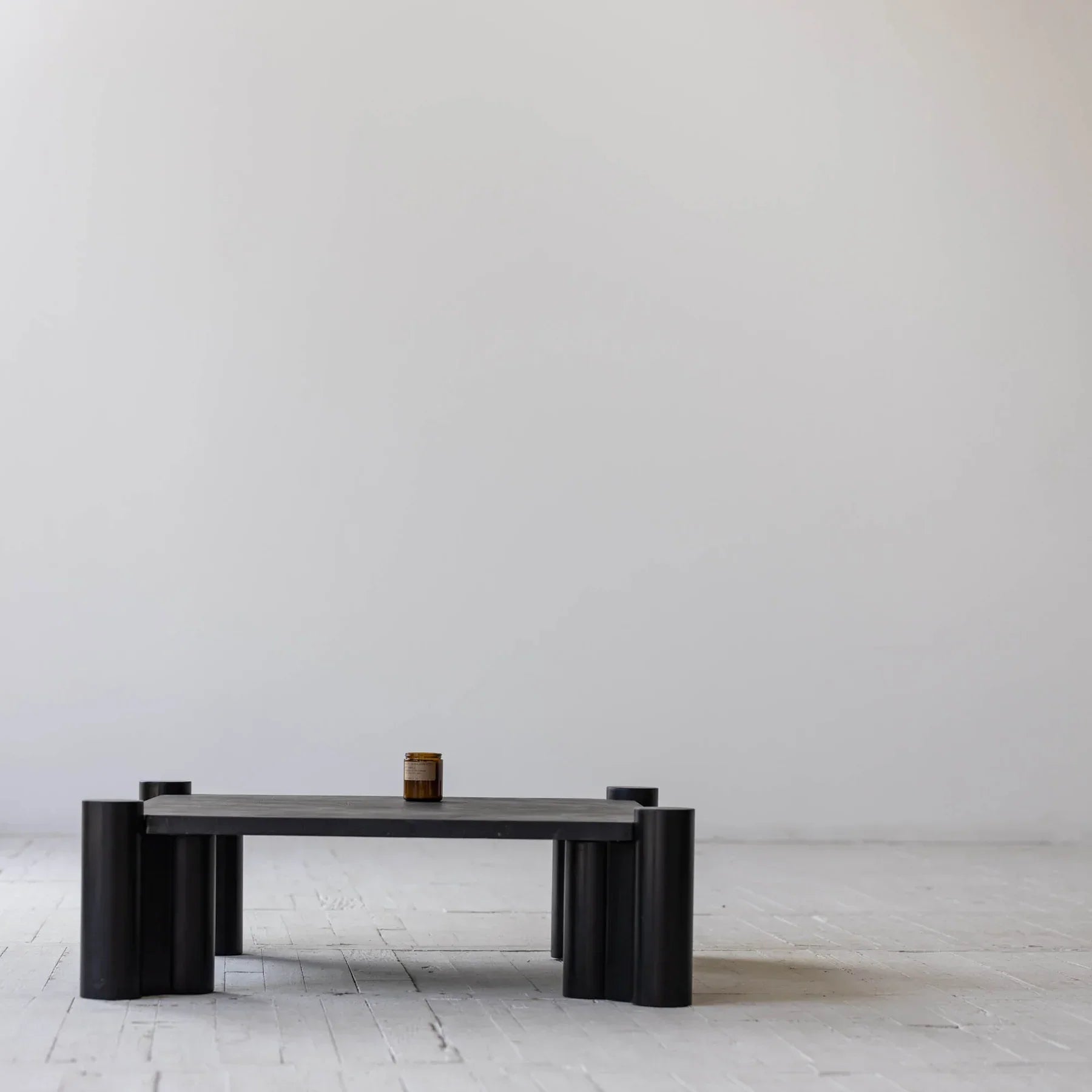 Front view of the Vito square coffee table in a matte black oak finish featuring thick fluted cylindrical legs