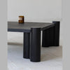 Close-up shot focusing on the natural wood grain texture and the vertical fluting on the oversized cylindrical legs